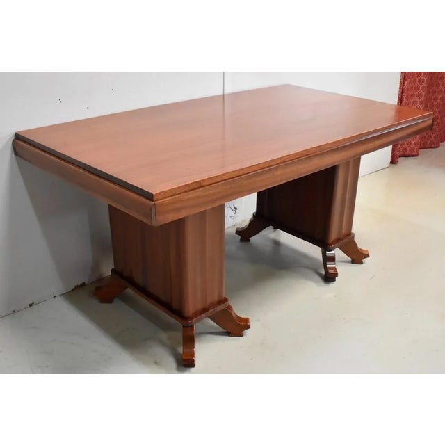 Rectangular table top with Mahogany veneered down slightly. It is extensible to end by a slide system for inserting two...