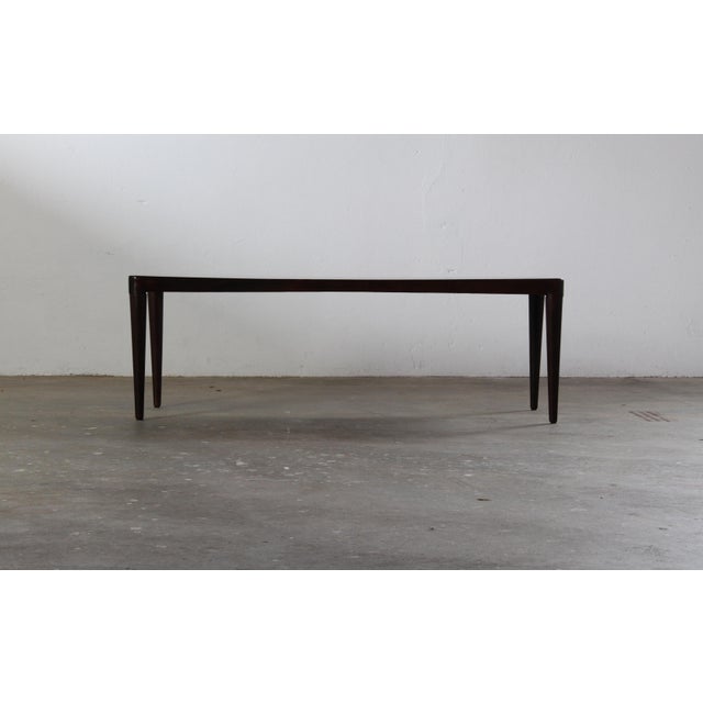 This exceptionally slim and elegant rosewood coffee table is a quintessential piece of 1960s Danish design, bearing the...