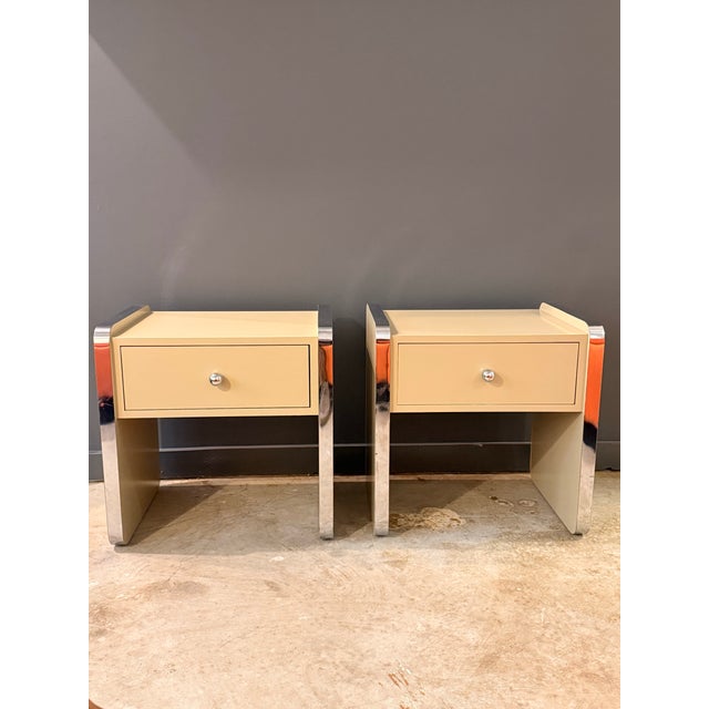 Pair of postmodern beige nightstands or end tables with chrome accents.