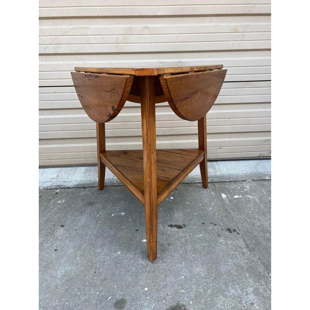 Vintage Early American Style Maple Handkerchief Drop Leaf Side Table. Features a round mitered plank top, lower shelf,...