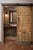 This dramatic hand-carved wood barn door features a repeating fleur-de-lis-inspired motif and rhythmic surface carving,...