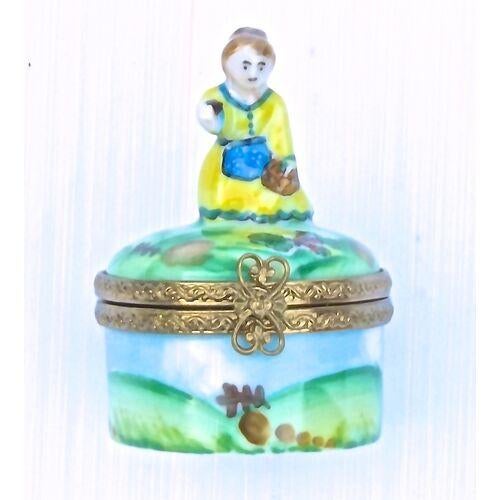 Vintage porcelain Limoges box with a maiden figurine on the lid. Brass edges with heart shaped brass clasp. Garden and...