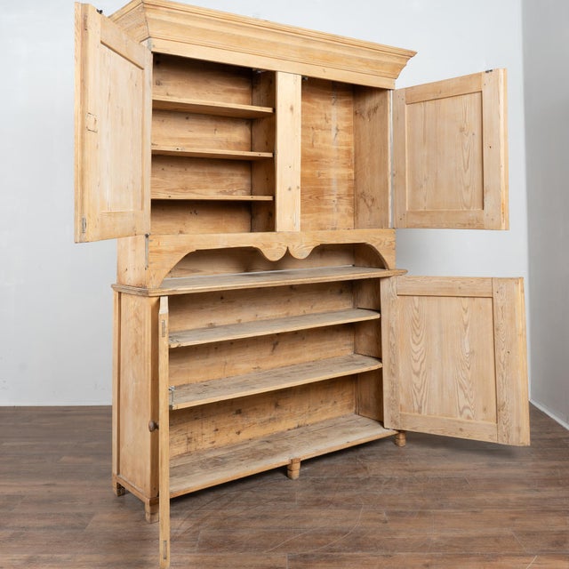 19th-century Swedish pine cabinet featuring four paneled doors with simple carved floral motifs at each corner. The...