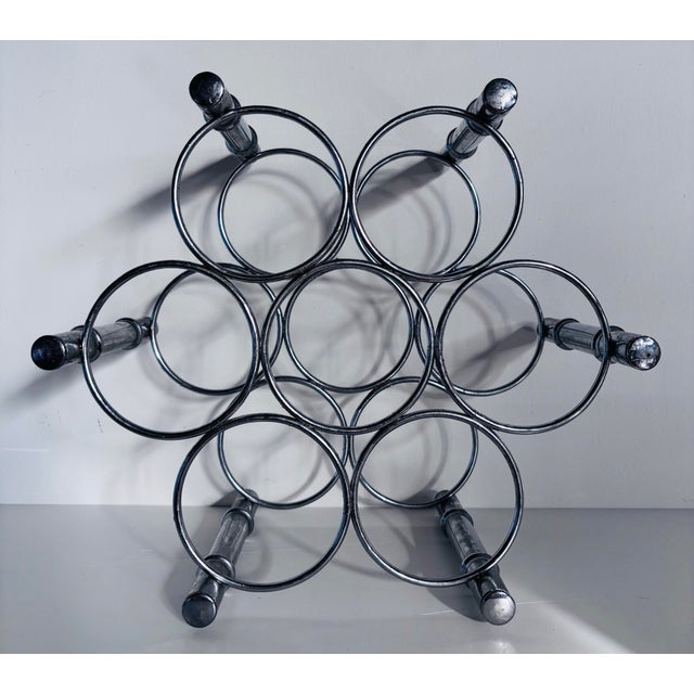 Unique circular shaped vintage wine rack in chrome finish. Space for seven bottles. Accented as faux chrome bamboo.
