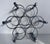Unique circular shaped vintage wine rack in chrome finish. Space for seven bottles. Accented as faux chrome bamboo.