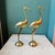 A stunning pair of mid-century brass cranes. Each has elegant etched detailing through the wings, legs and floral etching...