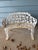 White cast iron grapevine garden table, chairs (2), and bench set. Splayed leaf leg profile. Possibly late Victorian to...