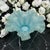 This blue opalescent ruffled bowl featuring crimped edge design and delicate color transitions from translucent blue to...