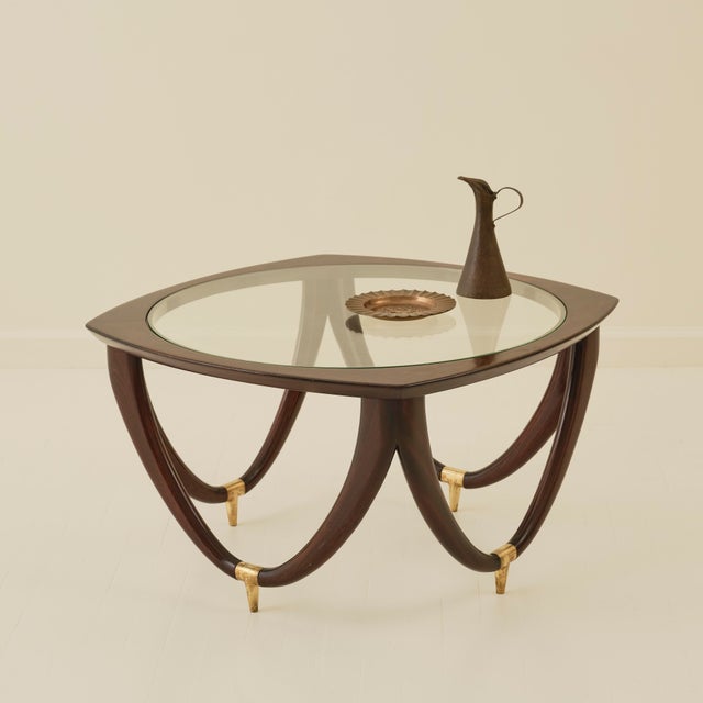Coffee table by Melchiorre Bega, made in Italy circa 1950. The table combines a wooden structure with a glass top and...