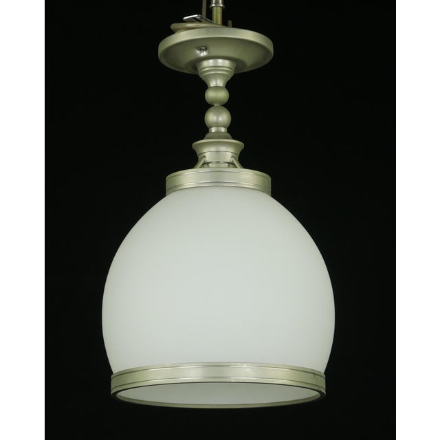 Modern style semi flush mount light with a white glass shade and brushed steel fitter and shade band. This light requires...
