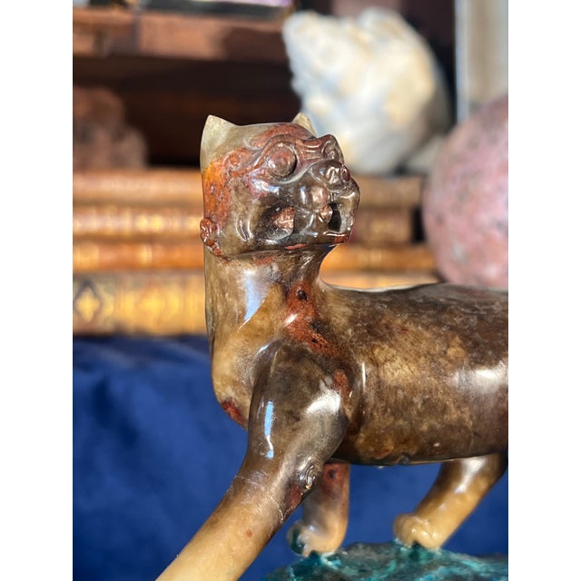 Beautiful pair of early 20th-century Chinese carvings features two lions meticulously crafted from mottled brown and tan...