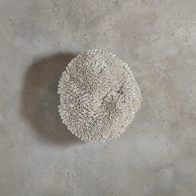 A textural round wall sculpture made from paper tubes, aqua resin, and acrylic on panel by Canadian artist Erin Vincent....