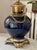 Stunning mid-century indigo blue table lamp with pleated shade and ornate brass details, including scroll feet and chain....