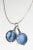 Silver neckring by Bent Knudsen, in an original, playful design. Two blue glass marbles caught in silver wire are...