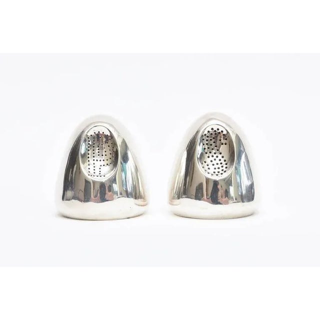This fabulous pair of hallmarked and signed vintage modernist sterling silver salt and pepper shakers are by the noted and...