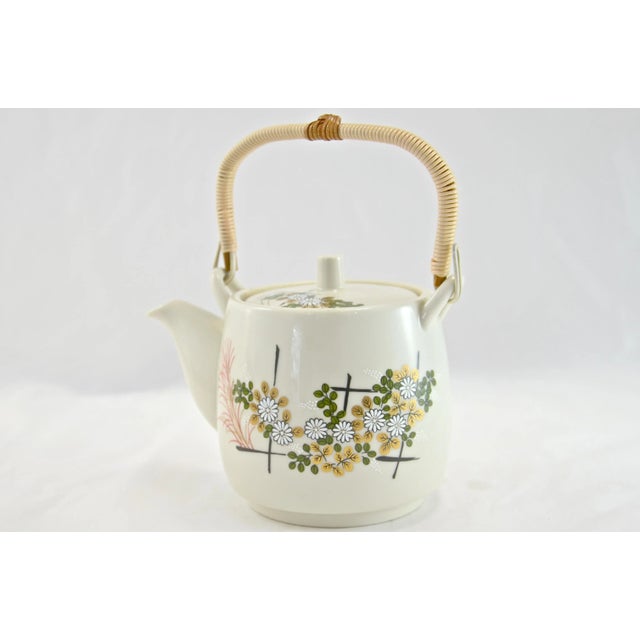 Vintage Japanese hand-decorated floral ceramic teapot with a wrapped split bamboo handle as well as a gold, green, and red...