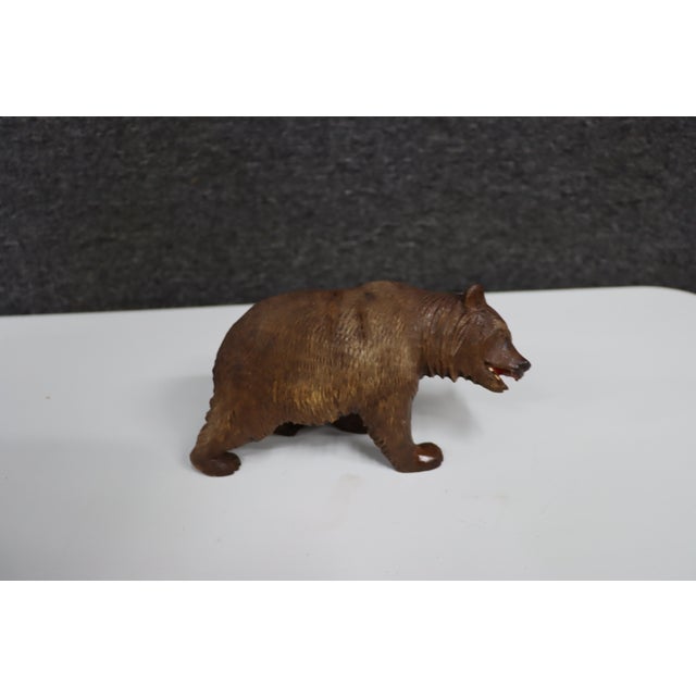 Hand-carved Black Forest-style wooden bear featuring detailed fur texture, a sculpted muzzle, and an open mouth with...
