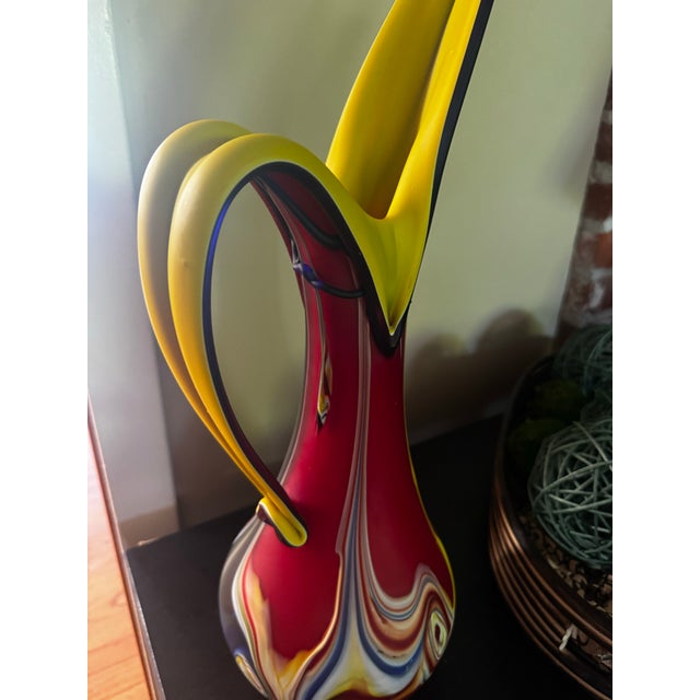 A striking vintage hand-blown art glass vase standing an impressive 20 inches tall. This sculptural piece features a...