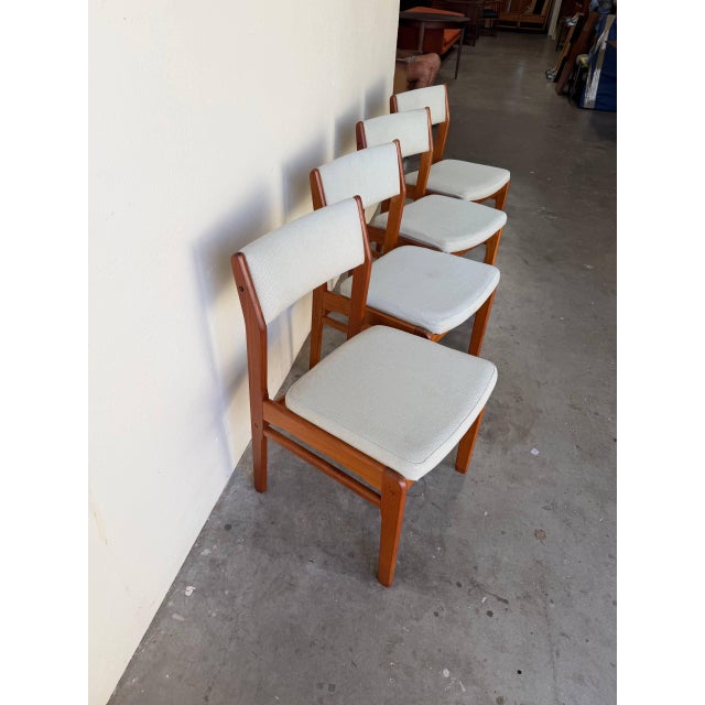 These chairs feature elegant Scandinavian lines with gently curved upholstered backrests and sculpted solid teak frames....