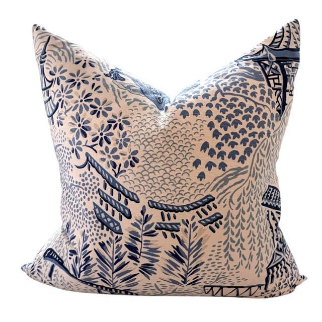 A striking chinoiserie-style accent pillow featuring a bold dragon motif in layered blue tones against a soft neutral...
