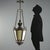 Iron lantern with a hexagonal truncated pyramid section, featuring a refined interplay of alternating white and yellow...