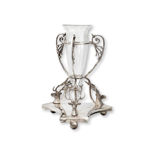 Victorian English centerpiece vase featuring a dramatic silverplate base formed with stag head mounts and branching...