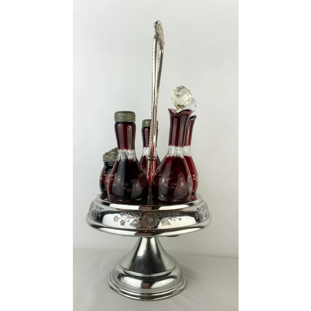 This gorgeous cruet set has been artfully designed. The server is in three parts: the base, bottle holder and handle. The...