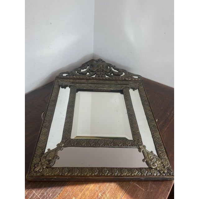A repoussé brass framed mirror, showcasing the craftsmanship and artistry typical of the second half of the 19th century....