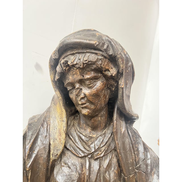 Carved wooden representation of Saint Anne Sculpture of a saint on a freestanding base, her gaze directed downwards The...