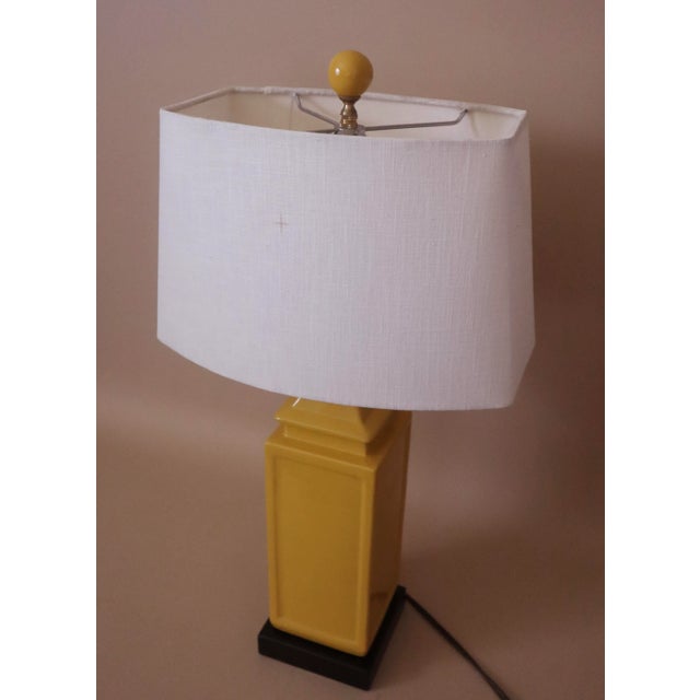 Yellow porcelain square lamp on bronze base with matching yellow round ceramic finial. Includes rectangular white linen...