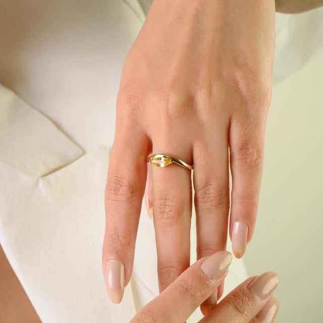 This luminous solitaire wave ring features 1 marquise cut yellow sapphire totaling 0.77 carats, set in solid 14K yellow...