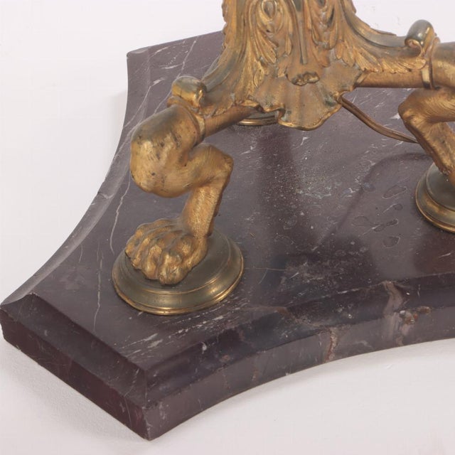 French Neoclassical style gilt bronze and marble floor lamp C 1900 having a white glass shade, above a foliate embellished...