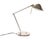 A 1990s Postmodern desk lamp by Tensor. The lamp is primarily silver in color with gold-tone accents. The angular shade...