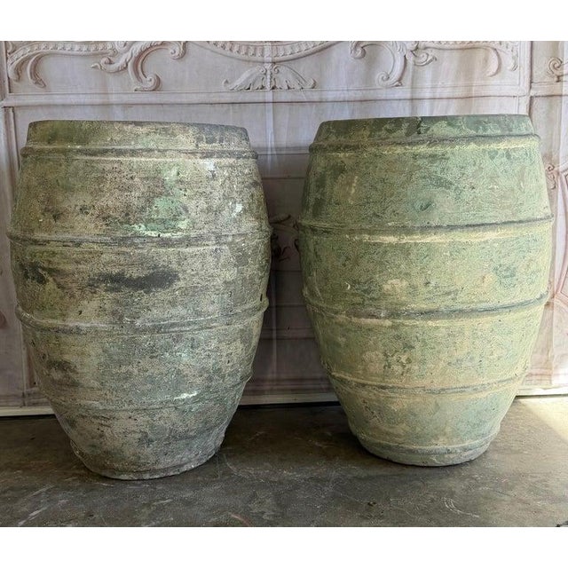 A pair of Mediterranean style barrel-form olive jars, commanding attention with their powerful sculptural presence and...