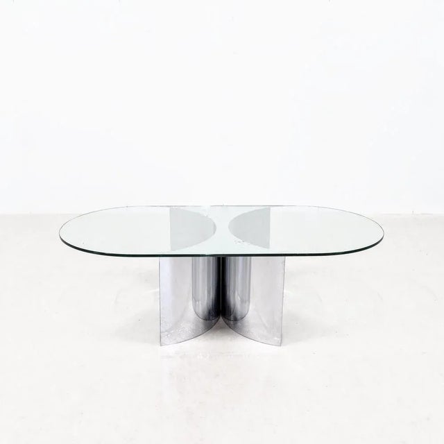 A large coffee table with a concave shaped base in chrome steel. Rounded glass top decorated with glass semi-circles....