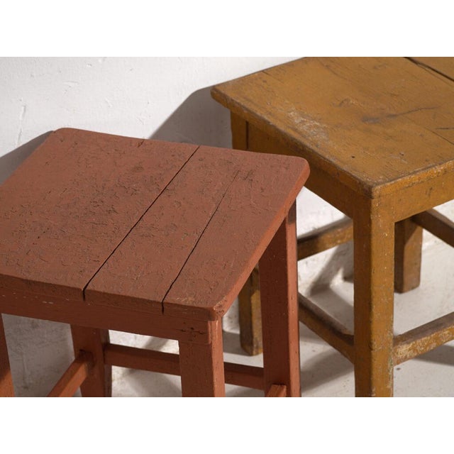 A pair of antique bedside tables in pine wood, with a square top and four tapered legs tied by box stretchers. They...