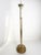 Large French floor candle holder dating from the 1970s, combining brass with a woven rattan base. Its tall, slender brass...