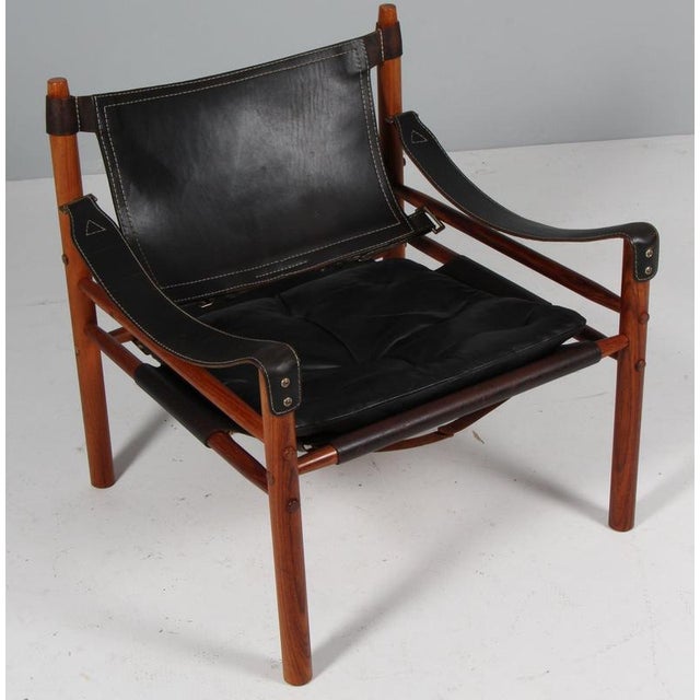 Arne Norell safari chair. Original upholstered foam cushions with patinated leather. Frame of rosewood. Model Scirocco,...