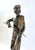 This bronze statue depicts a man gracefully playing the violin, captured in a lifelike and elegant pose. Standing 21...