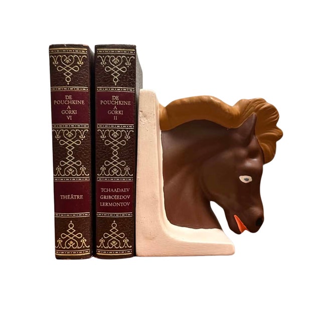 A distinctive vintage ceramic bookend featuring a stylized horse's head emerging from a sculptural L-shaped support....