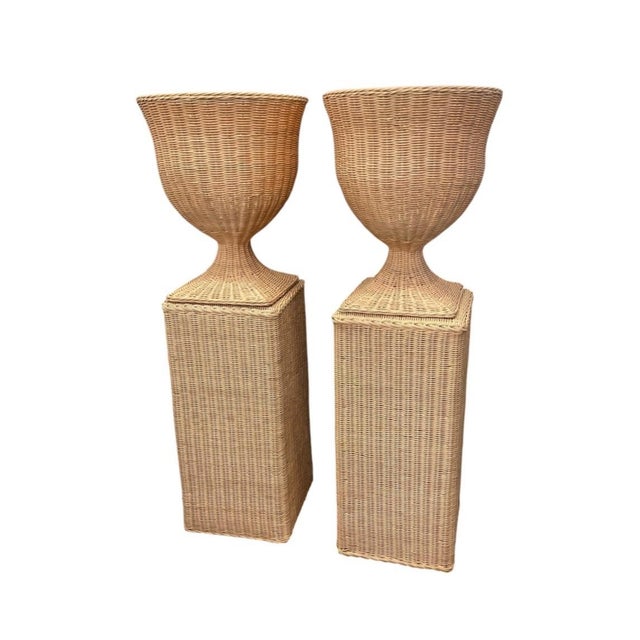 Elevate your interior space with this striking pair of vintage woven wicker urn planters set atop matching square pedestal...