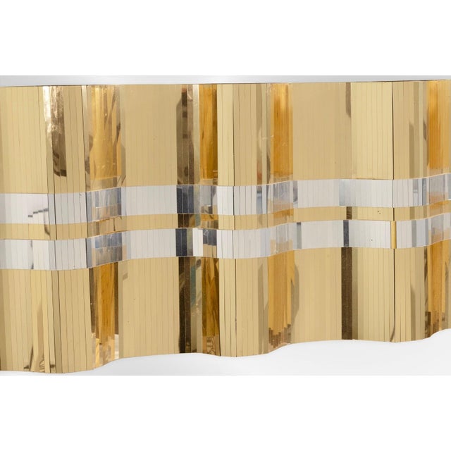This Mixed Silver and Gold Metal Mirrored Hanging Wall Sculpture is a striking statement piece that blends reflective...