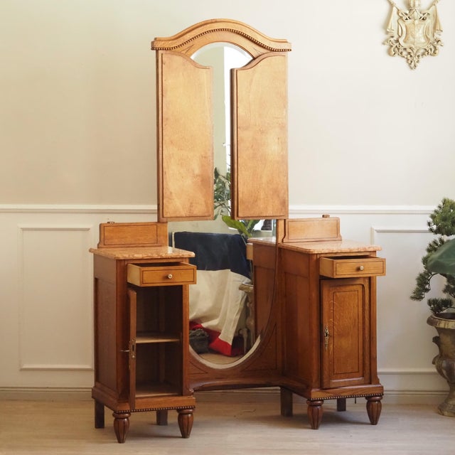 An elegant oak dressing table with a three-panel folding mirror and original marble tops, dating from around 1900 during...