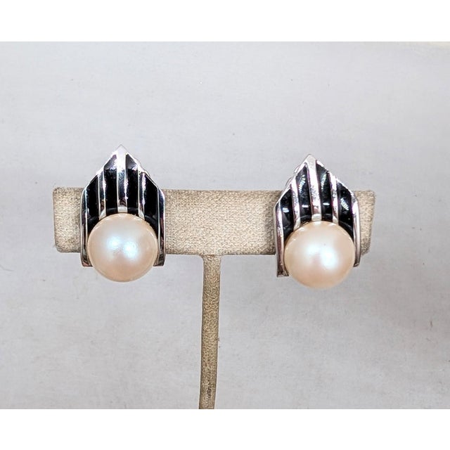 1980s Art Deco style rhodium plated faux-mabe pearl bottoms with vertical black enamel stripes on top hexagonal clip...
