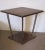 French modernist lacquered walnut side table, architectural in design with cubist lines. The diamond shaped top is held by...