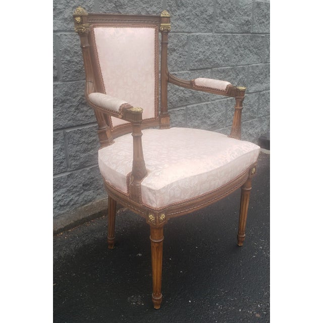An Early 20th Century Louis XV Mahogany and Giltwood Upholstered Armchair in good condition with rose color upholstery....