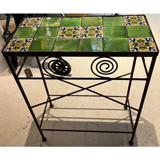 A striking vintage Spanish Revival / Mediterranean console table featuring a handcrafted ceramic tile top set within a...