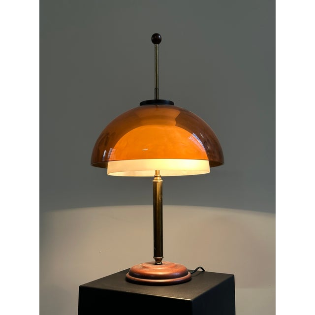 1960s table lamp, Italian-made by Reggiani. The lamp has two lampshades: one external in brown acrylic glass, the other...