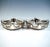 A pair of festive, elegant silver baskets with a square base, standing on four spherical feet; the sides gently curved...