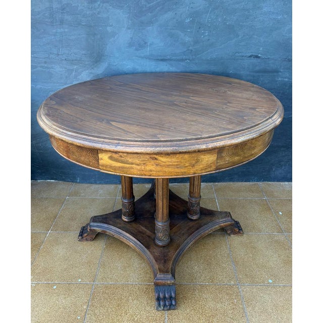 Spanish round table crafted in solid wood, dating to the early 20th century. The design reflects the historicist...